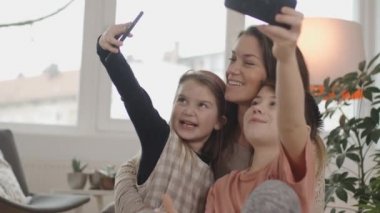 Anne ve iki çocuk yeni evlerinde selfie çekiyorlar. Güzel bir oturma odası. Slovenya 'da vuruldu