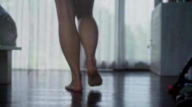 caucasian woman opening the curtains of her home and stepping outside to the pool, early in the morning. Vacation 