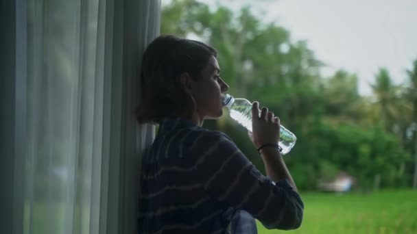 Bouteille d'eau à son porche avec une belle vue sur la nature vivante . — Video