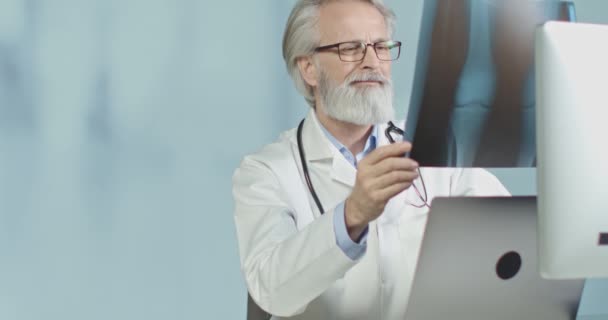 Médico no consultório a ver radiografias e tomografias. — Vídeo de Stock