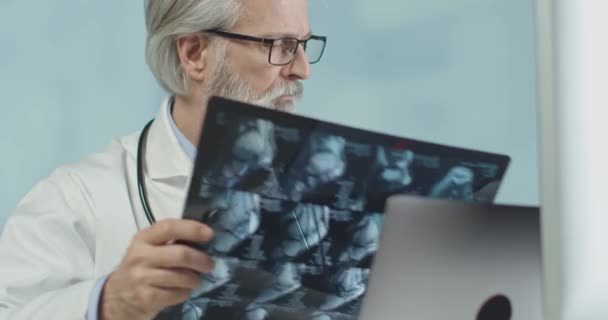 Gros plan d'un médecin de son bureau regardant des radios et des scans. Infection à couronne — Video