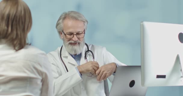 Médico hablando con una paciente en su consultorio. 4k cámara lenta — Vídeos de Stock
