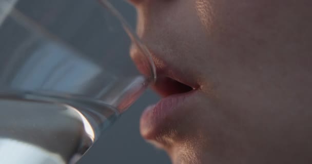 Primer plano de los labios femeninos beber agua de un vaso transparente. 4k cámara lenta — Vídeo de stock