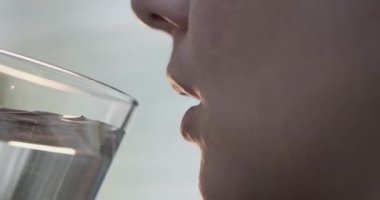 Kadın şeffaf bir bardaktan su içiyor. 4k ağır çekim