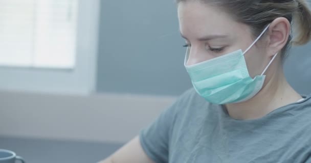Joven mujer caucásica que trabaja desde casa con una máscara, durante la estancia en casa corona veces — Vídeos de Stock