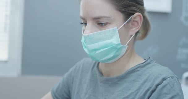 Joven mujer caucásica que trabaja desde casa con una máscara, durante su estancia en casa corona veces — Vídeos de Stock