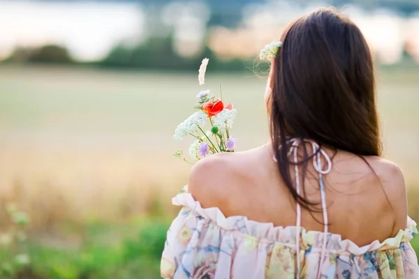 Vista posterior de la mujer joven vestida con vestido de verano tienen ramo —  Fotos de Stock