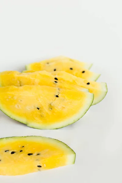 Corte uma fatia de melão amarelo maduro em um fundo branco — Fotografia de Stock