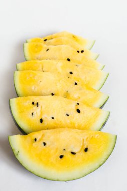 beyaz bir arka plan üzerinde olgun sarı kavun bir dilim kesmek