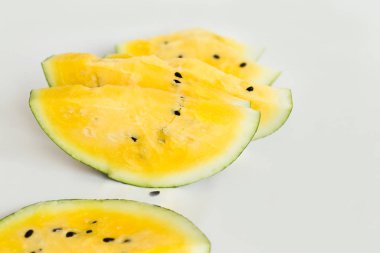 beyaz bir arka plan üzerinde olgun sarı kavun bir dilim kesmek