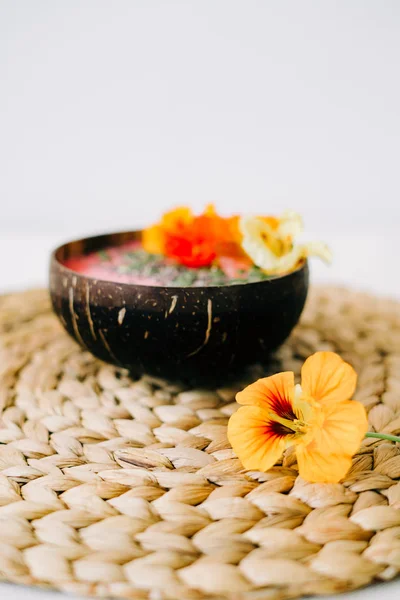 Zdrowe śniadanie w talerzu kokosa z nasturcji kwiaty na naturalnej wiklinowej serwetce — Zdjęcie stockowe
