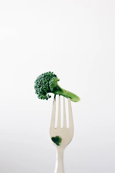 A fork with a green inflorescence of fresh broccoli on a white background. vegan food — Stock Photo, Image