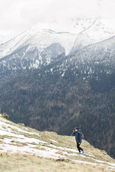 Uma jovem viajante sobe um topo de montanha coberto de neve — Fotografia de Stock