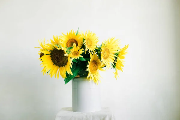 Csokor világos sárga napraforgó virágok egy retro váza fehér alapon — Stock Fotó