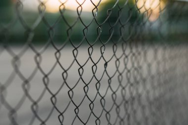 Arkasında bir spor sahası olan çit ızgarasının panoramik görüntüsü