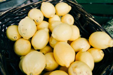 Olgun sarı limonlar organik pazarda hasır bir sepette yatıyor.