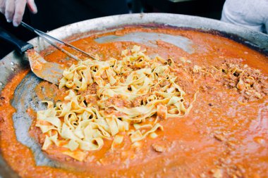 Lezzetli Bolonez makarnası büyük bir tavada pişirilmiş, sokak yemeği.