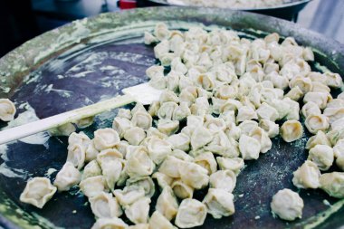 Kremalı soslu sokak yemeğinin içinde büyük bir tavada ravioli pişirilir.