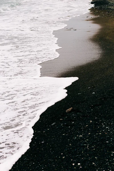 Sahile siyah volkanik kumla bir deniz dalgası geliyor. İzlanda 'nın güzel doğal geçmişi — Stok fotoğraf