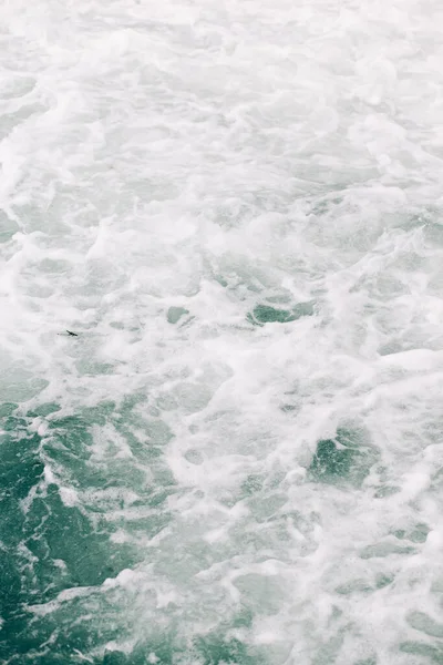 Hirviendo espuma marina de una ola que se rompió en una roca. fondo marino natural — Foto de Stock