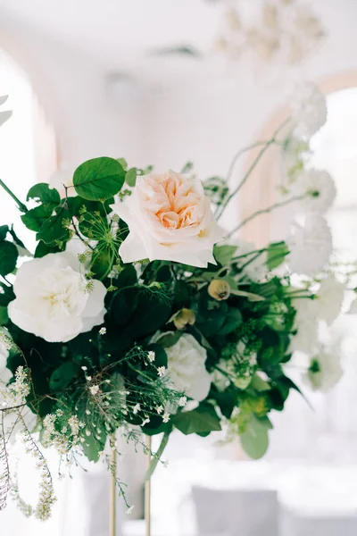 Gyönyörű virágos elrendezése finom rózsa virágok és friss növényzet a design az esküvői asztal a fehér teremben — Stock Fotó