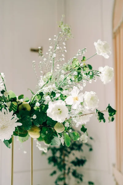 Esküvői asztalok virágos díszítése, finom fehér virágok és friss zöld ágak a fehér csarnokban — Stock Fotó