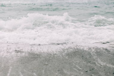 Deniz dalgası kumlu kıyıya ulaşır. .