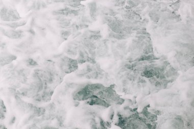 Kayanın üstünde kırılan bir dalganın köpüğü kaynıyor..