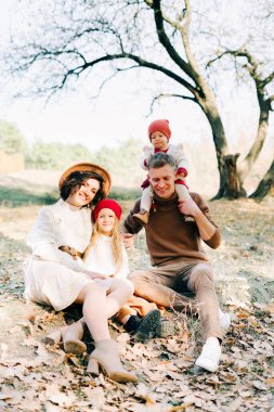 Sonbaharda bir çam ormanının ortasında dört kişilik mutlu bir aile.