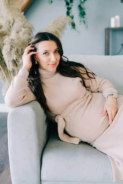 Retrato Una Joven Mujer Embarazada Hermosa Vestido Beige Sentado Sofá — Foto de Stock