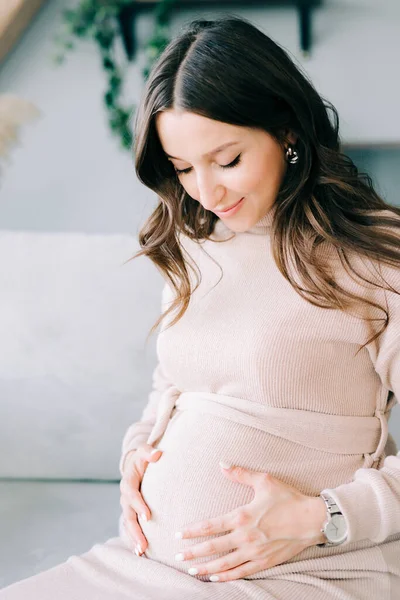 Retrato Una Joven Mujer Embarazada Hermosa Vestido Beige Sentado Sofá — Foto de Stock