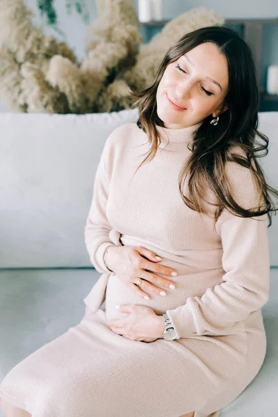 Retrato Una Joven Mujer Embarazada Hermosa Vestido Beige Sentado Sofá — Foto de Stock