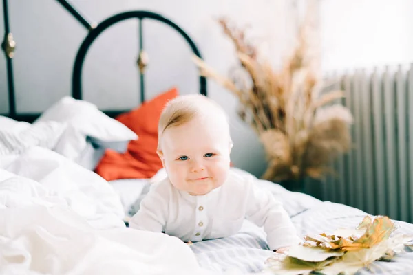 Mały Szczęśliwy Chłopiec Leży Jasnym Łóżku Uśmiechając Się — Zdjęcie stockowe