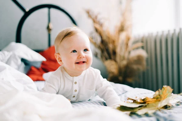 Mały Szczęśliwy Chłopiec Leży Jasnym Łóżku Uśmiechając Się — Zdjęcie stockowe