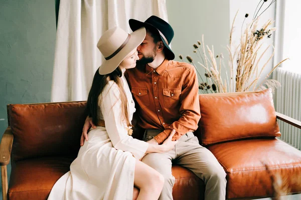 Casal Elegante Amor Com Chapéus Sentados Sofá Marrom Abraçando — Fotografia de Stock