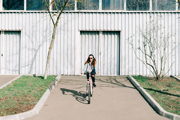 Egy Fiatal Stílusos Lány Rózsaszín Biciklin Fényes Hangár Mellett Lovagol — Stock Fotó