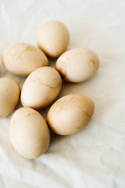 Masada açık bir masa örtüsünün üzerinde çatlaklarla boyanmış yedi Paskalya yumurtası var. Üst Manzara. En az stil. Paskalya konsepti
