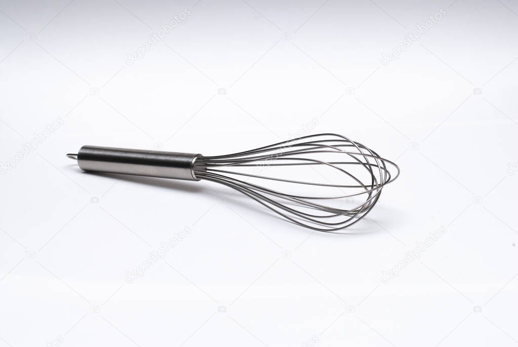 Stainless steel whisk in a white background