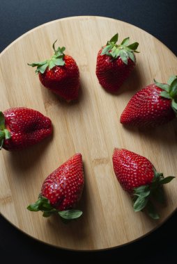 Yuvarlak ahşap tepside 6 taze çilek