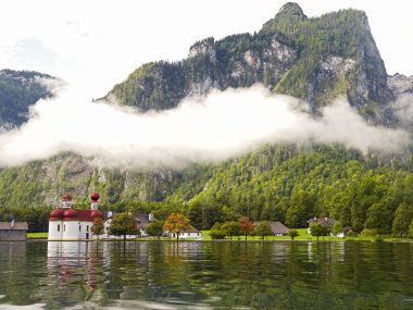 view of mountain scenery with Lake Konigssee with famous Sankt Bartholomae pilgrimage church Berchtesgaden Germany