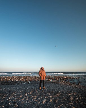 Sahilde gün batımlı bir adam