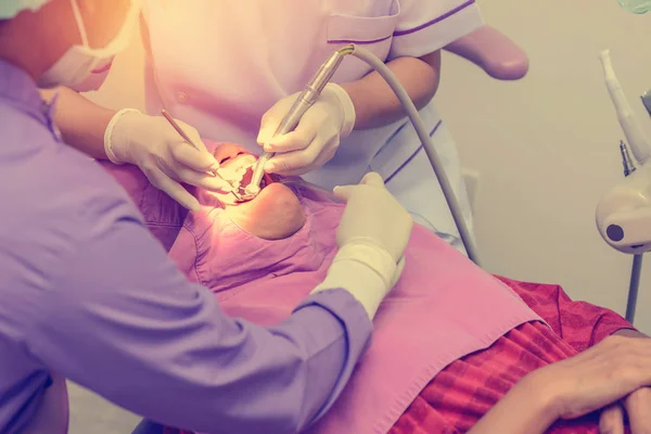 Dentist cleaning the teeth patient with ultrasonic tool — Stock Photo, Image