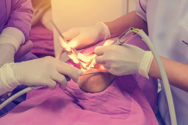 Dentist cleaning the teeth patient with ultrasonic tool — Stock Photo, Image