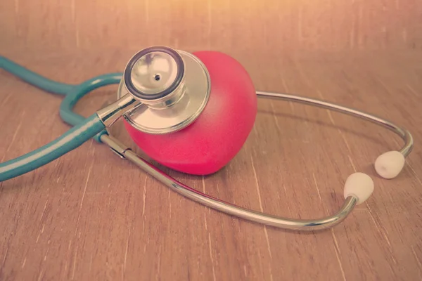 Red heart and stethoscope on wooden background — Stock Photo, Image