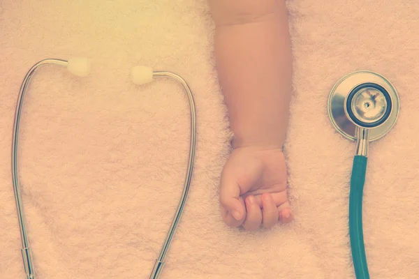 Медицинские инструменты стетоскоп в руке новорожденной девочки — стоковое фото