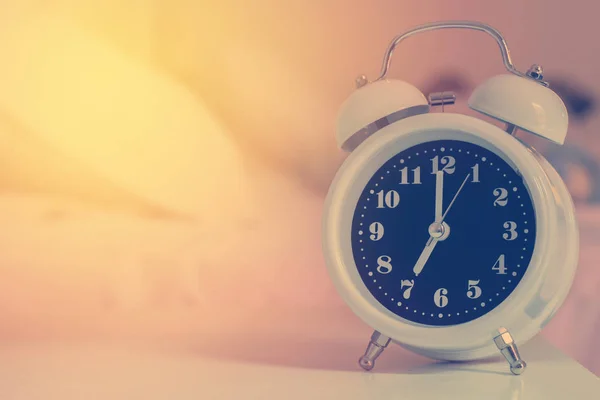 Despertador en la cama en el dormitorio, estilo retro —  Fotos de Stock