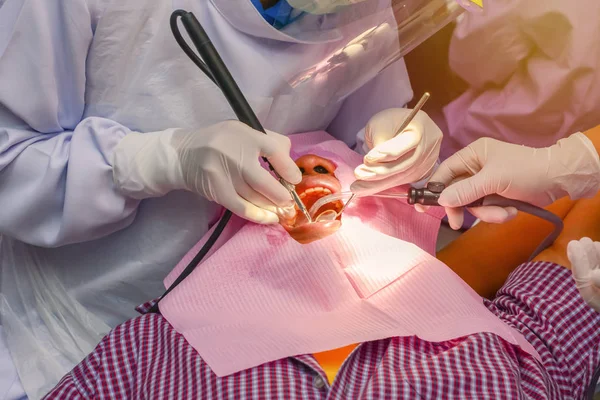 Dentist cleaning the teeth patient with ultrasonic tool — Stock Photo, Image