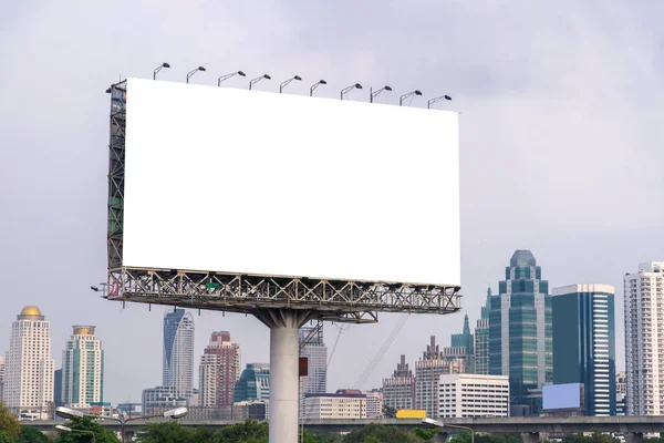 Grande outdoor em branco na estrada com vista para a cidade fundo — Fotografia de Stock