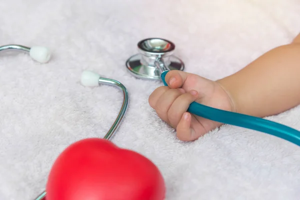 Yeni doğan bebek kız elinde stetoskop tıp aletleri — Stok fotoğraf
