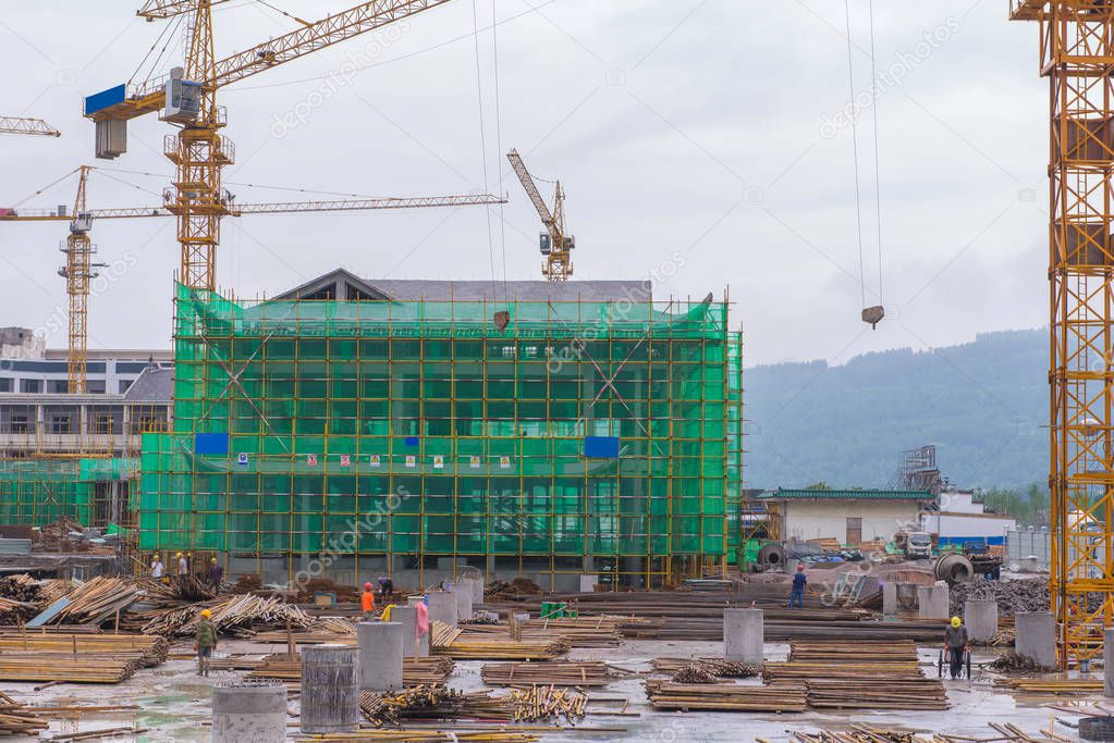 Crane and workers at Building construction site in progress